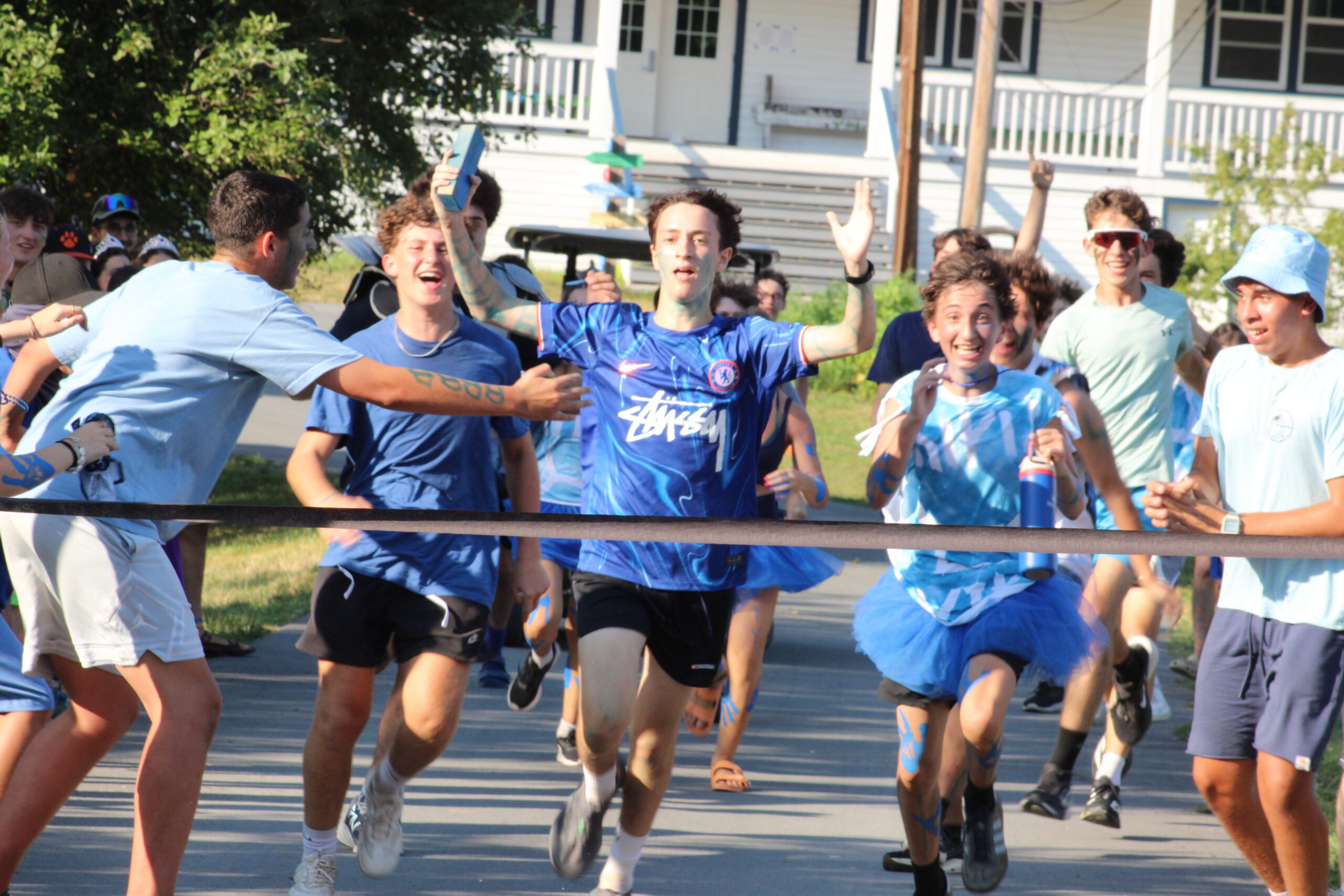 Campers cheering and running through a finish line banner