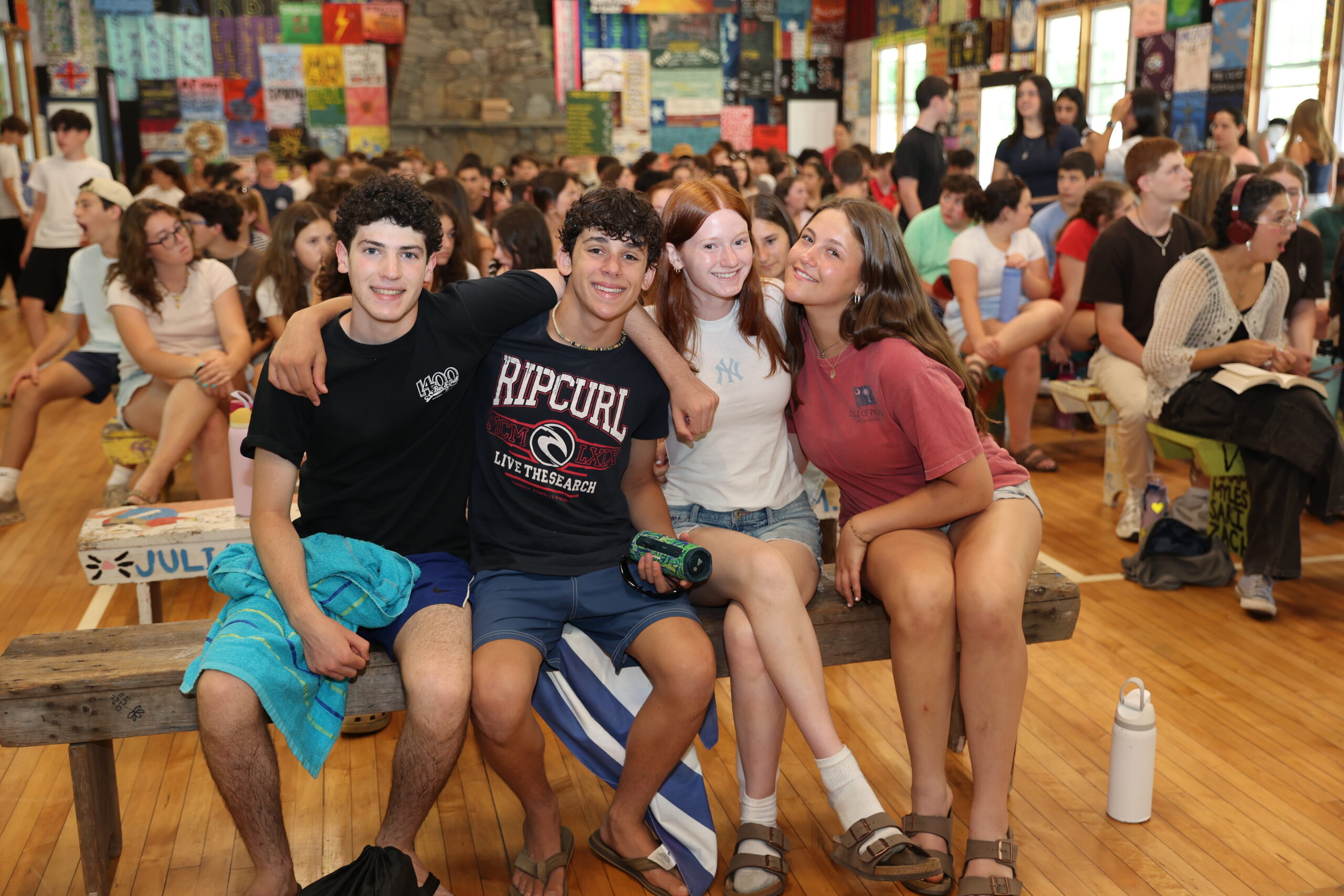 Teens laughing together in a packed camp dining hall